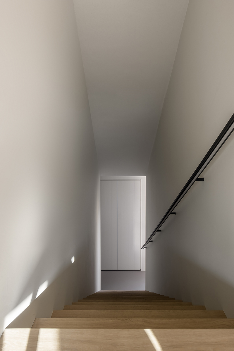 Maatwerk interieur door Studio Doccia. Eiken houten vloer loop door als trap. Maatwerk trapleuning met led-verlichting, ontwerp Oliver Drent.