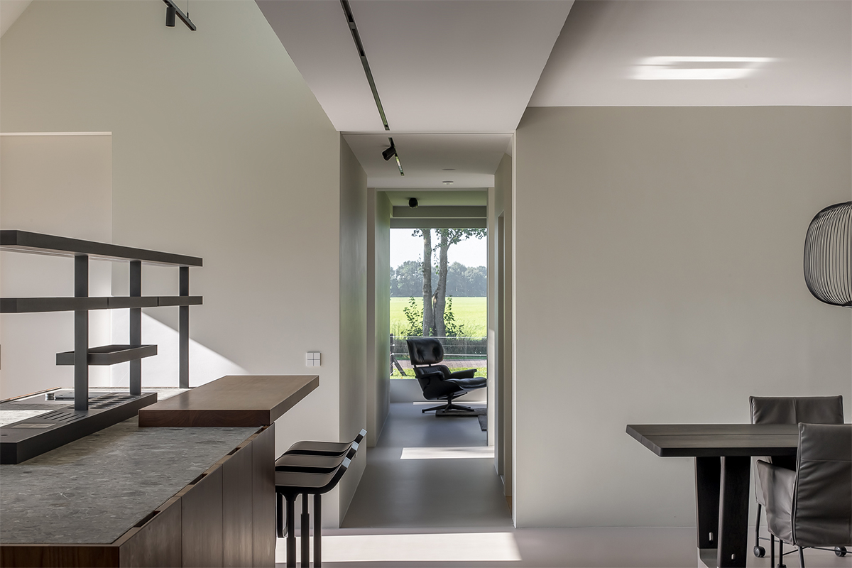 Maatwerk interieur en keuken door Studio Doccia, doorkijk van keuken naar living met gietvloer.